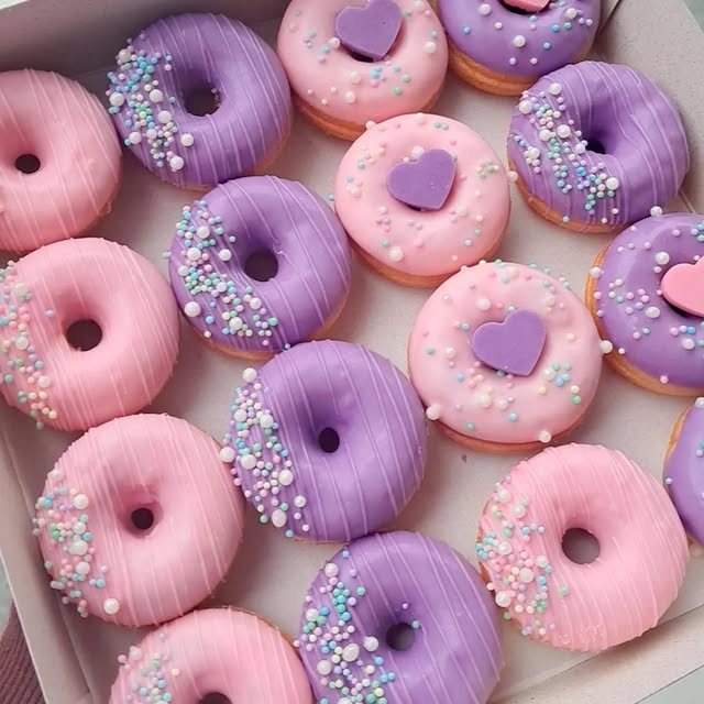 Mini cake donuts com cobertura rosa e lilás, confeitos coloridos e corações